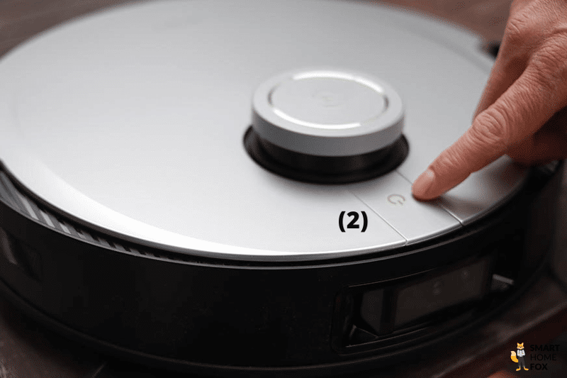 The control button on the Deebot X1 Robot Vacuum Cleaner is tapped with the finger